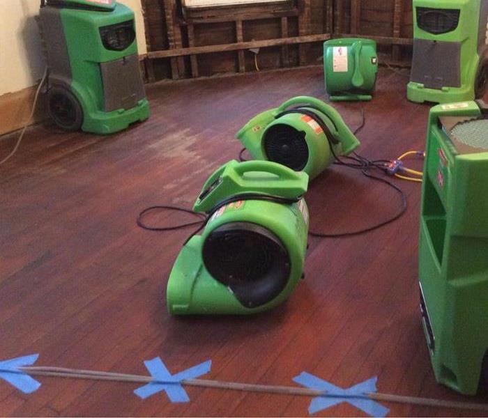 Air movers being used to dry up the water damage on the floor